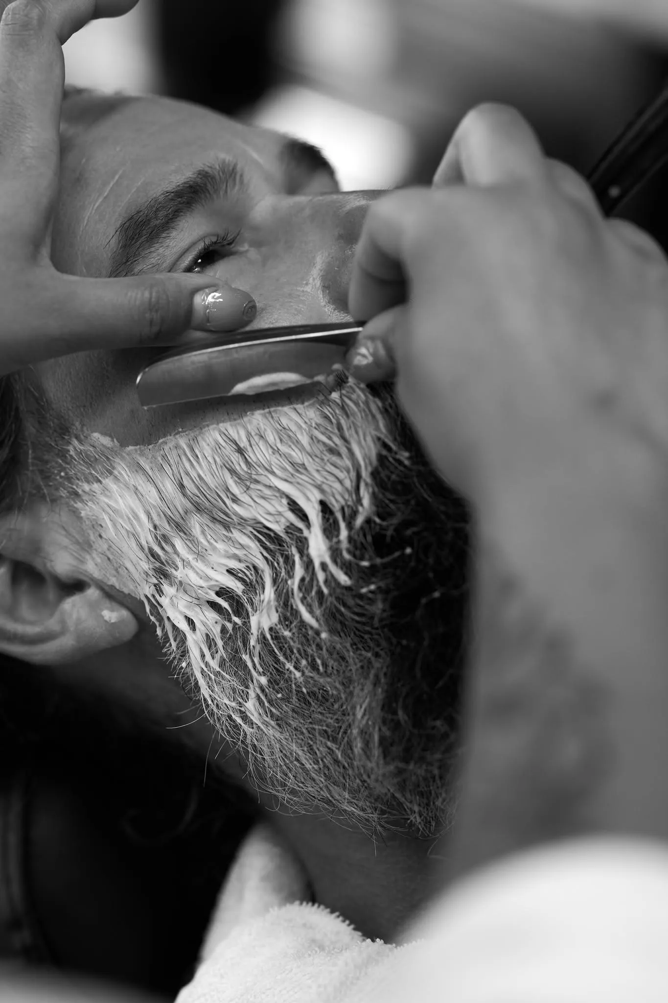 Close up black and white frame of a man sipping espresso