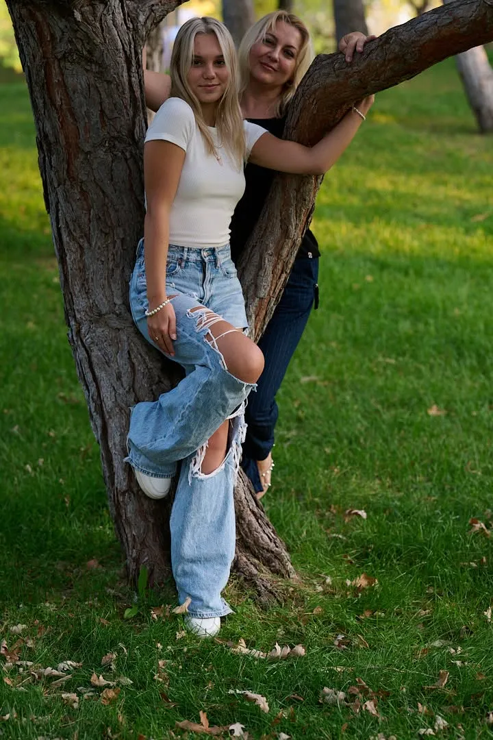 A mother and daughter together by a tree