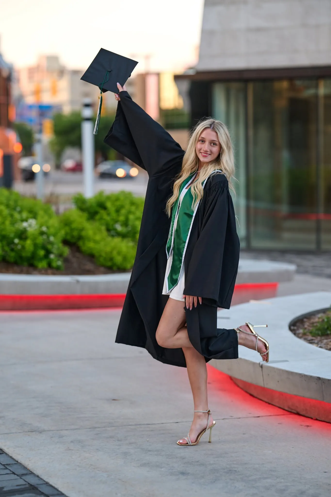 Graduate posing on campus steps