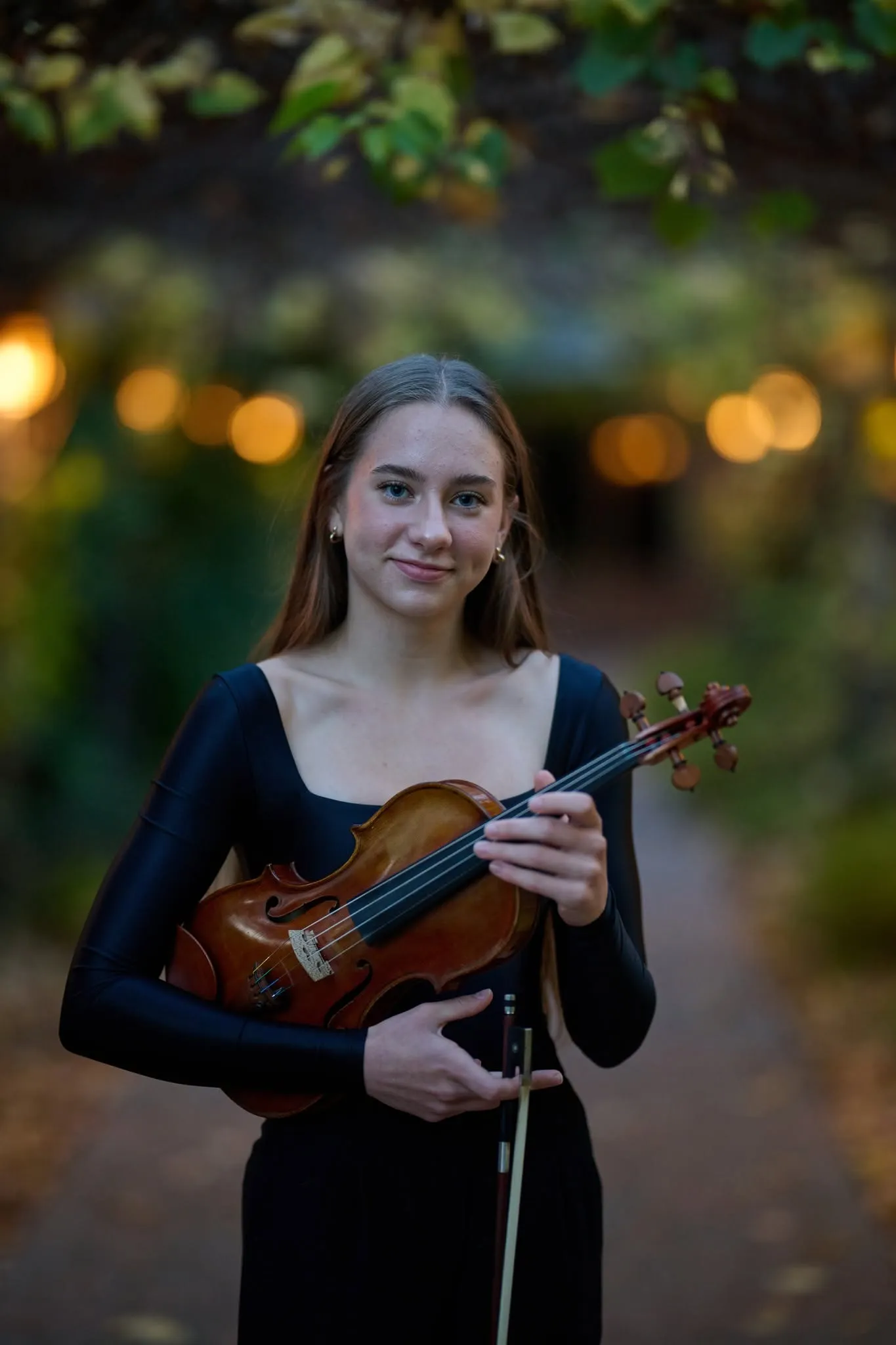 Violinist in a black dress in a garden